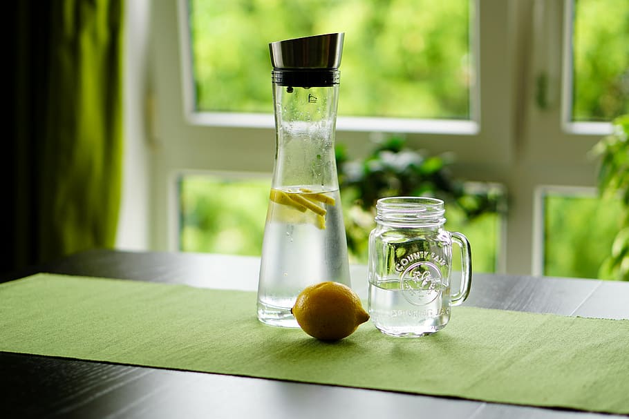 shallow focus photography of sliced lemon in glass bottle with water HD wallpaper
