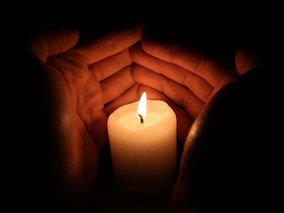 macro photography of white pillar candle, light, hands, flame