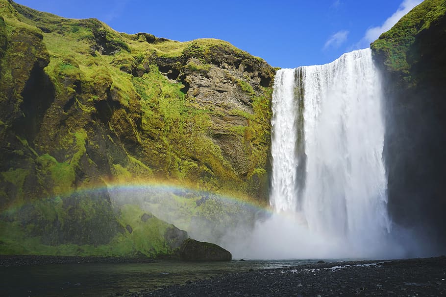Skogafoss, waterfalls rushing in to the water with rainbow screengrab HD wallpaper
