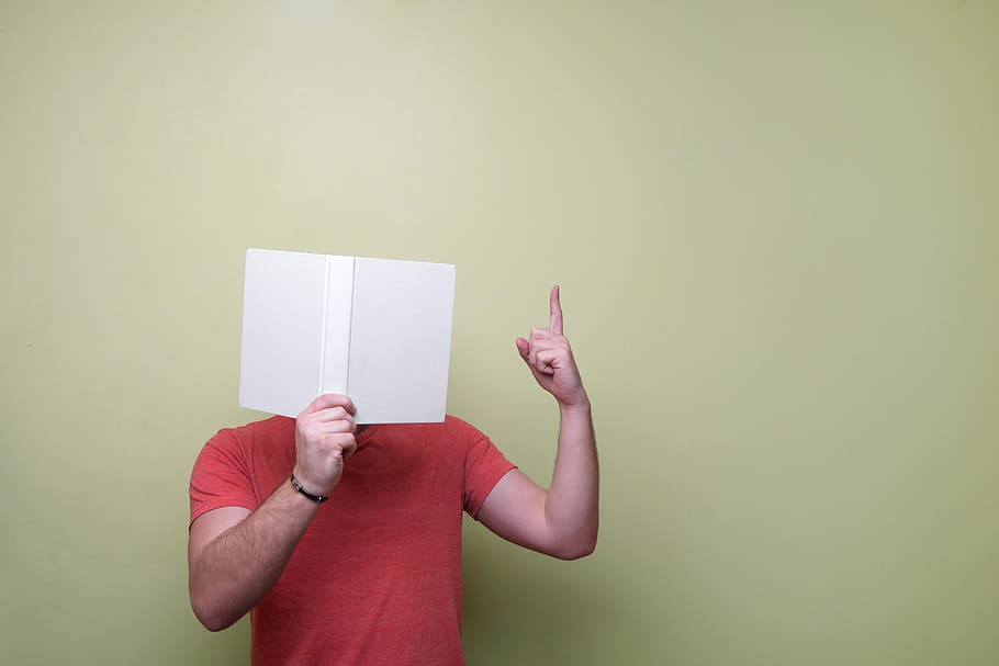 man in red crew-neck top holding paper, book, reading, guy HD wallpaper