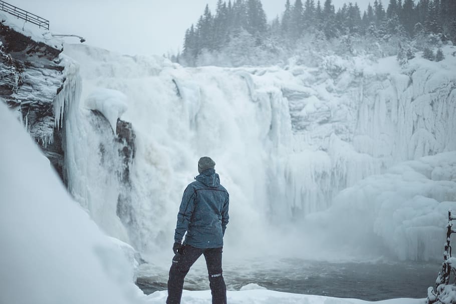 man standing near snow covered falls during daytime, man standing near on waterfalls HD wallpaper