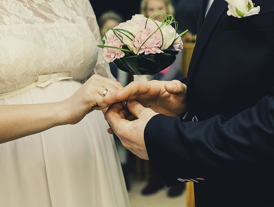 man and woman holding hand together beside petaled flowers HD wallpaper