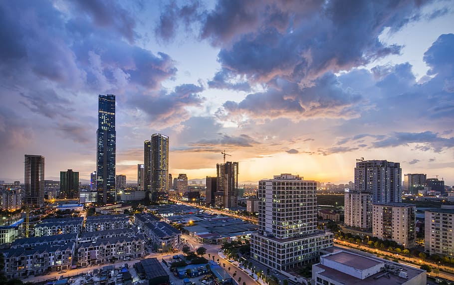 gray high-rise buildings under gray clouds during golden hour, aerial view photography of buildings under cloudy sky HD wallpaper