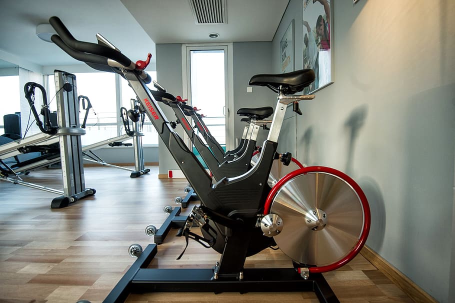 several assorted-color stationary bikes inside gym, weights, bicycle