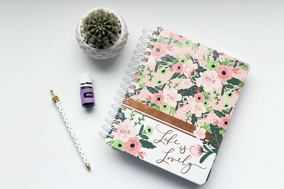 white and pink floral notebook on table, spiral notebook and pencil on white panel, HD wallpaper