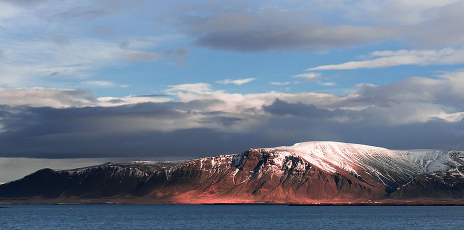 tabletop mountain near body of water, brown rocky mountain beside body of water under dark clouds HD wallpaper