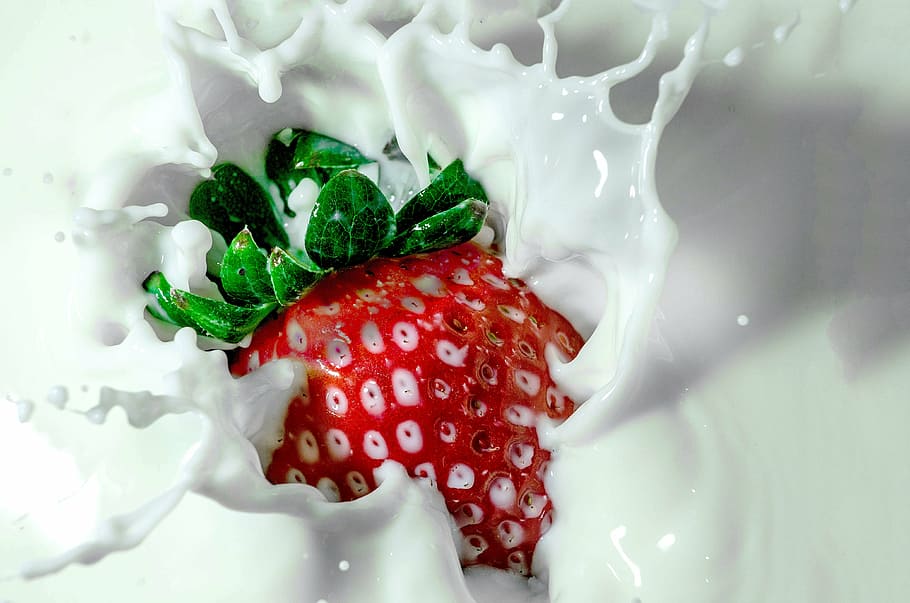 timelapse photography of strawberry tossed into milk, strawberry milk