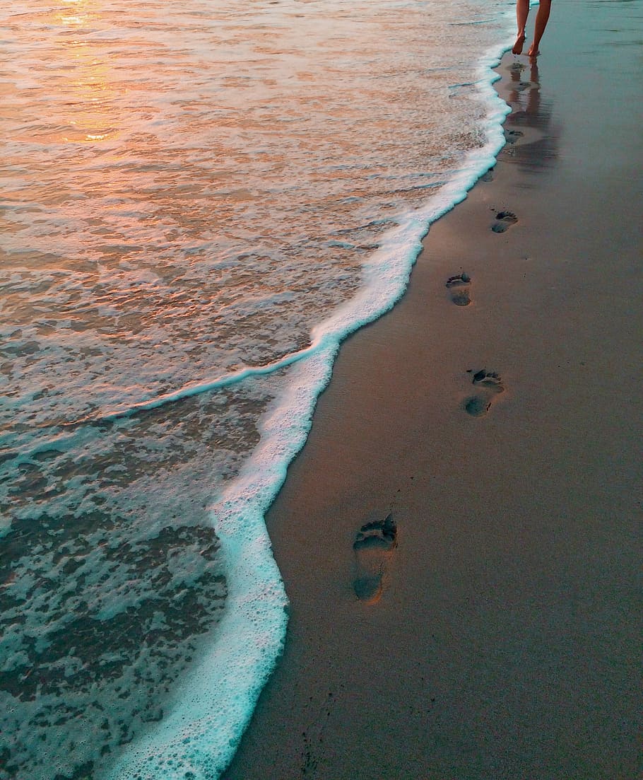 footprints on seashore, person leaves footprint on shore during golden hour HD wallpaper