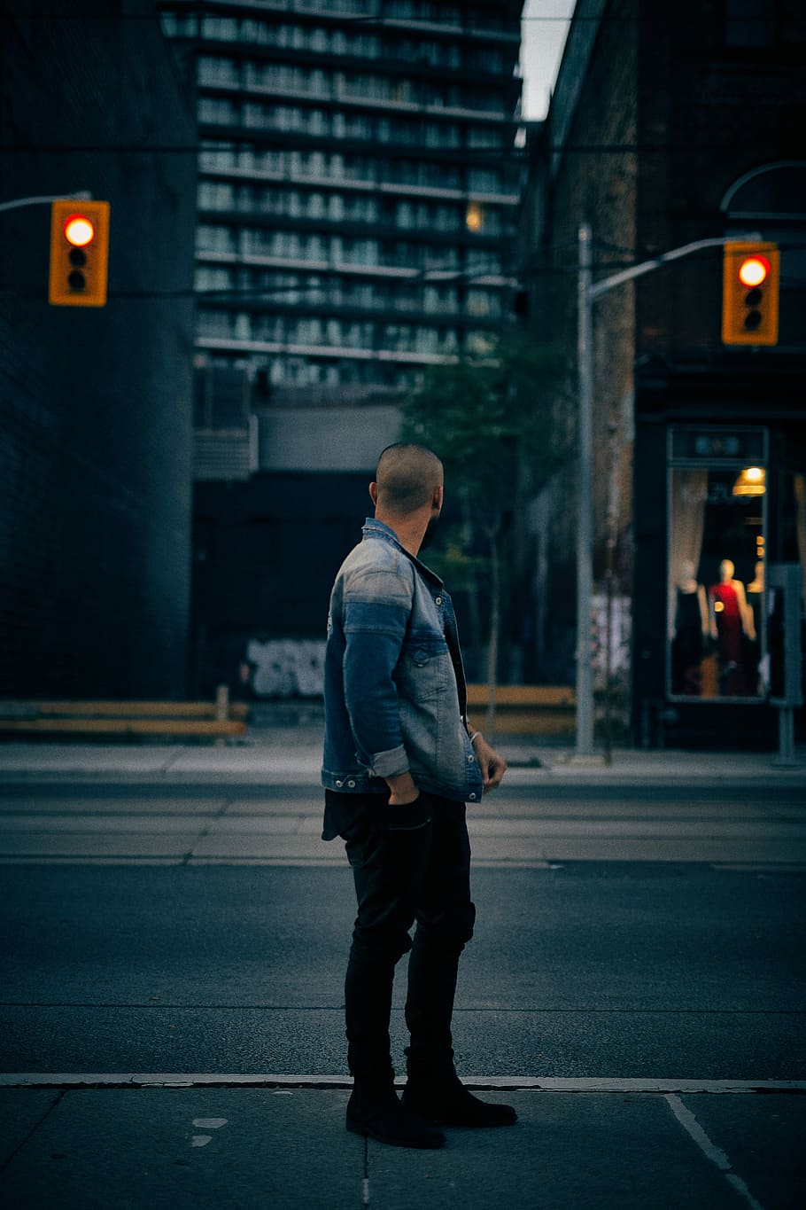 man standing near tall building and traffic lights, man looking at his back HD wallpaper