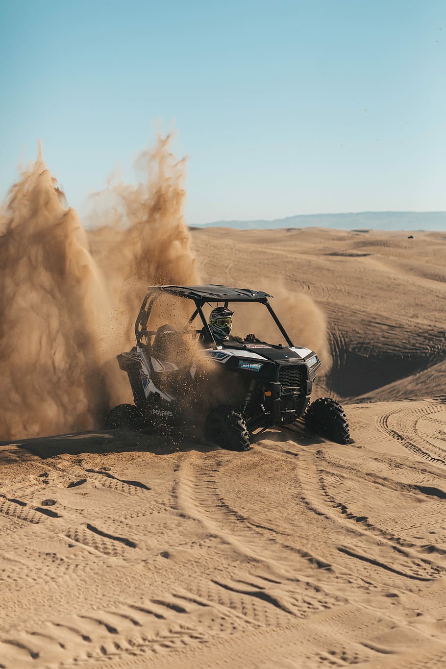 person riding an UTV on desert, man riding on black and gray dune buggy on desert