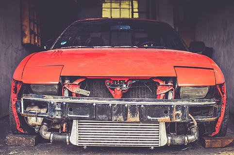 closeup photography of orange car parked between concrete walls HD wallpaper