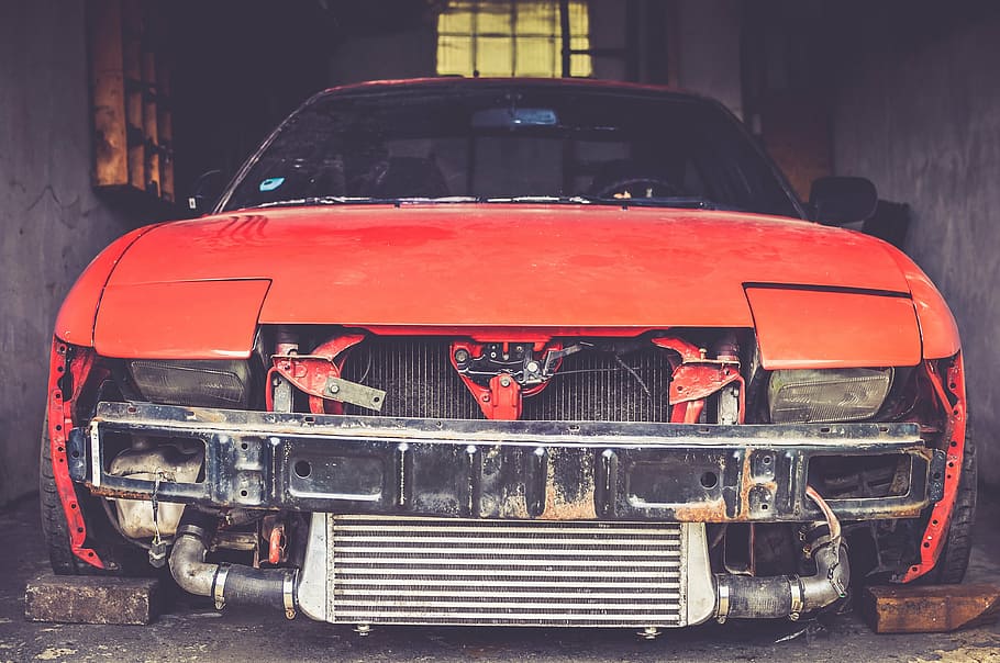 closeup photography of orange car parked between concrete walls HD wallpaper