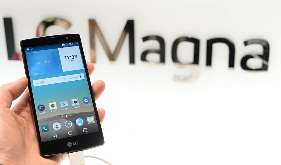 person holding LG Magna Android smartphone, mobile phone, tech