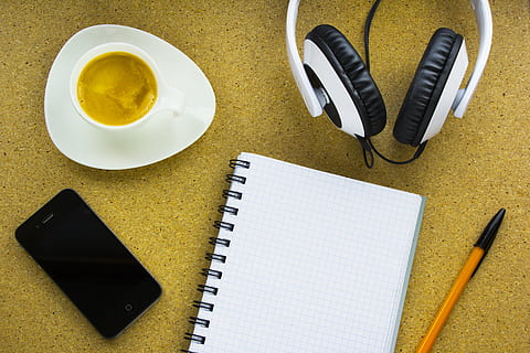 flat-lay photography of notebook, smartphone, pen, cup of coffee, and wired headphones HD wallpaper
