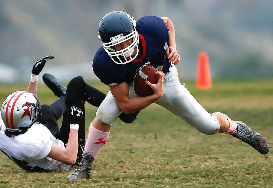 two men playing football, running back, ball carrier, action