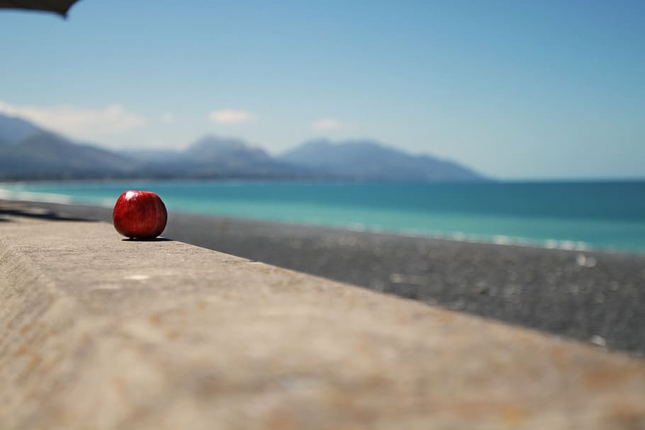 red apple fruit on top of gray stone, beach, landscape, mountains HD wallpaper