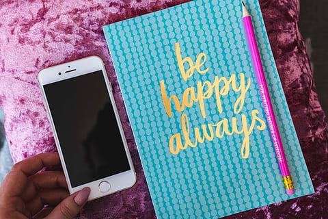 Blue notebook with a pink iPhone, headphones and a sweet bun HD wallpaper