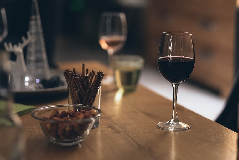 black liquid in clear wine glass on brown wooden table, clear wine glass beside clear glass bowl HD wallpaper