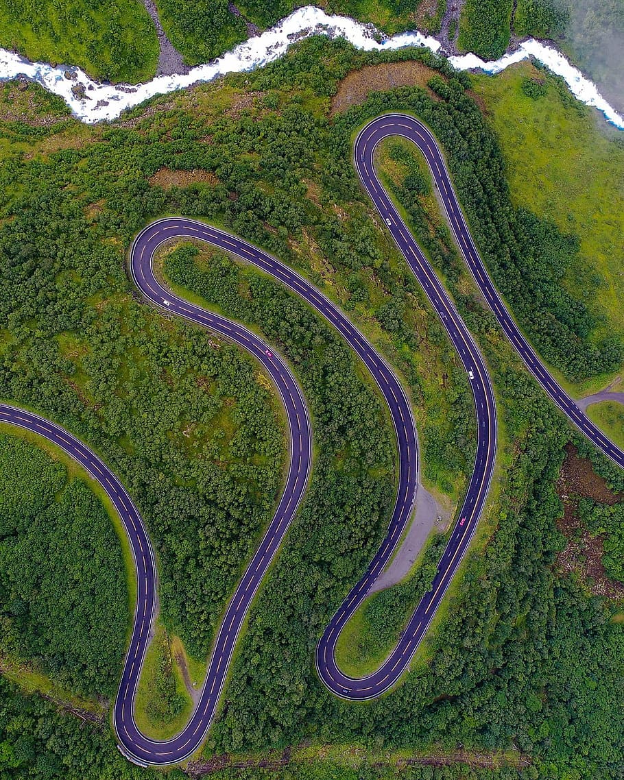 aerial photo of gray concrete roadway near trees during daytime, aerial view of zig-zag road with trees HD wallpaper