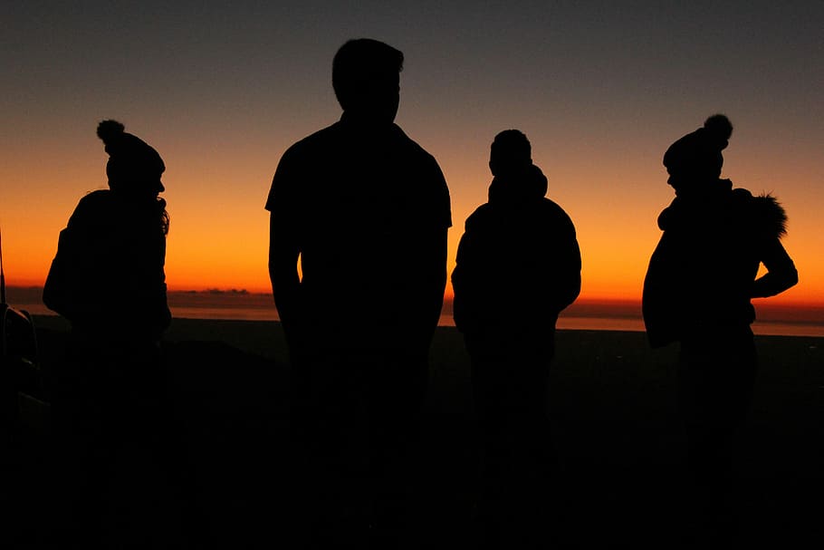 four persons standing during sunset, silhouette of four men standing
