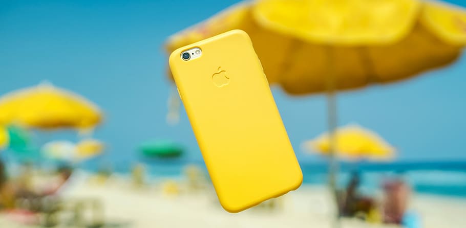 iPhone with yellow cover hanging on air, silver iPhone 7 with yellow iPhone case on air