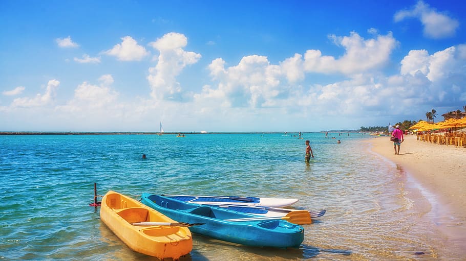 three white, yellow, and blue wooden paddle boats on body of water near seashore at daytime HD wallpaper