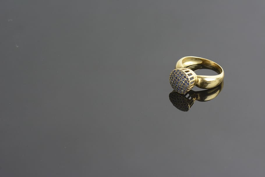 gold-colored clear gemstone ring on gray surface, Background