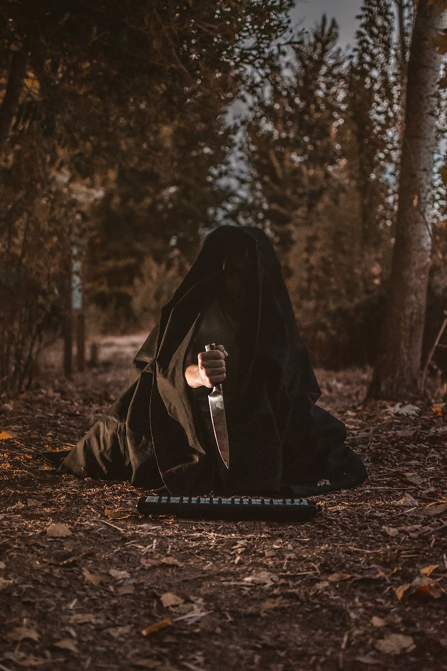 person holding knife with black textile cover, person in black cloak holding knife in forest, HD wallpaper