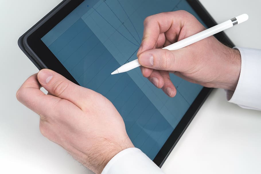 person writing in a tablet computer using stylus, pencil, electronic