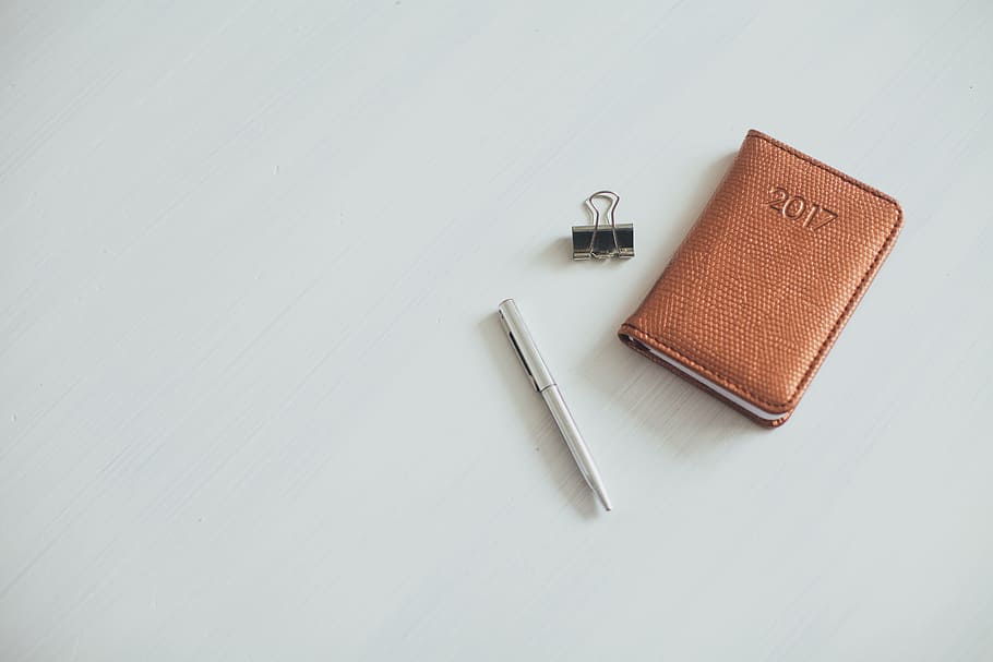 gray twist pen beside brown leather wallet and paper clip on white surface, HD wallpaper