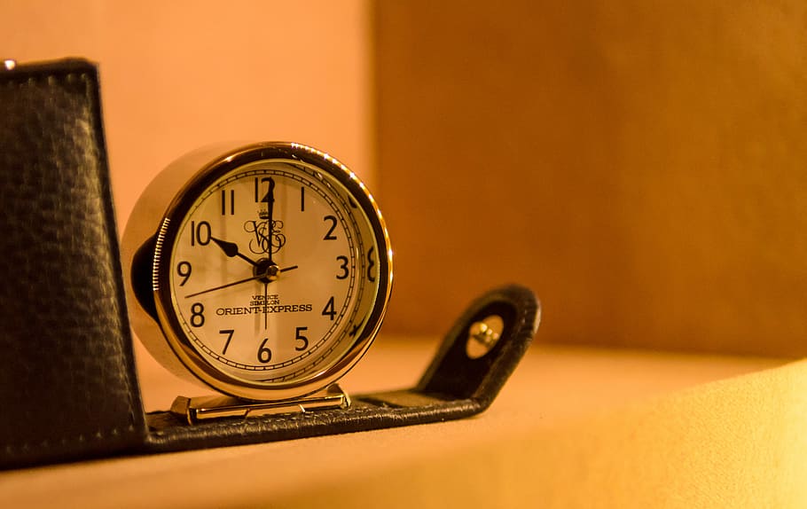 white and black table clock, round silver alarm clock beside black leather case HD wallpaper