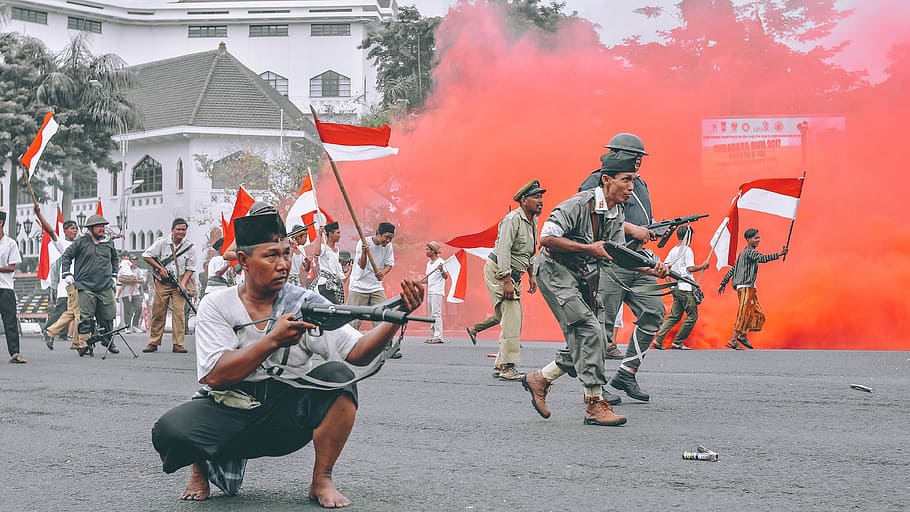 man holding gun during daytime, man squat while holding a gun in the middle of a day rally HD wallpaper