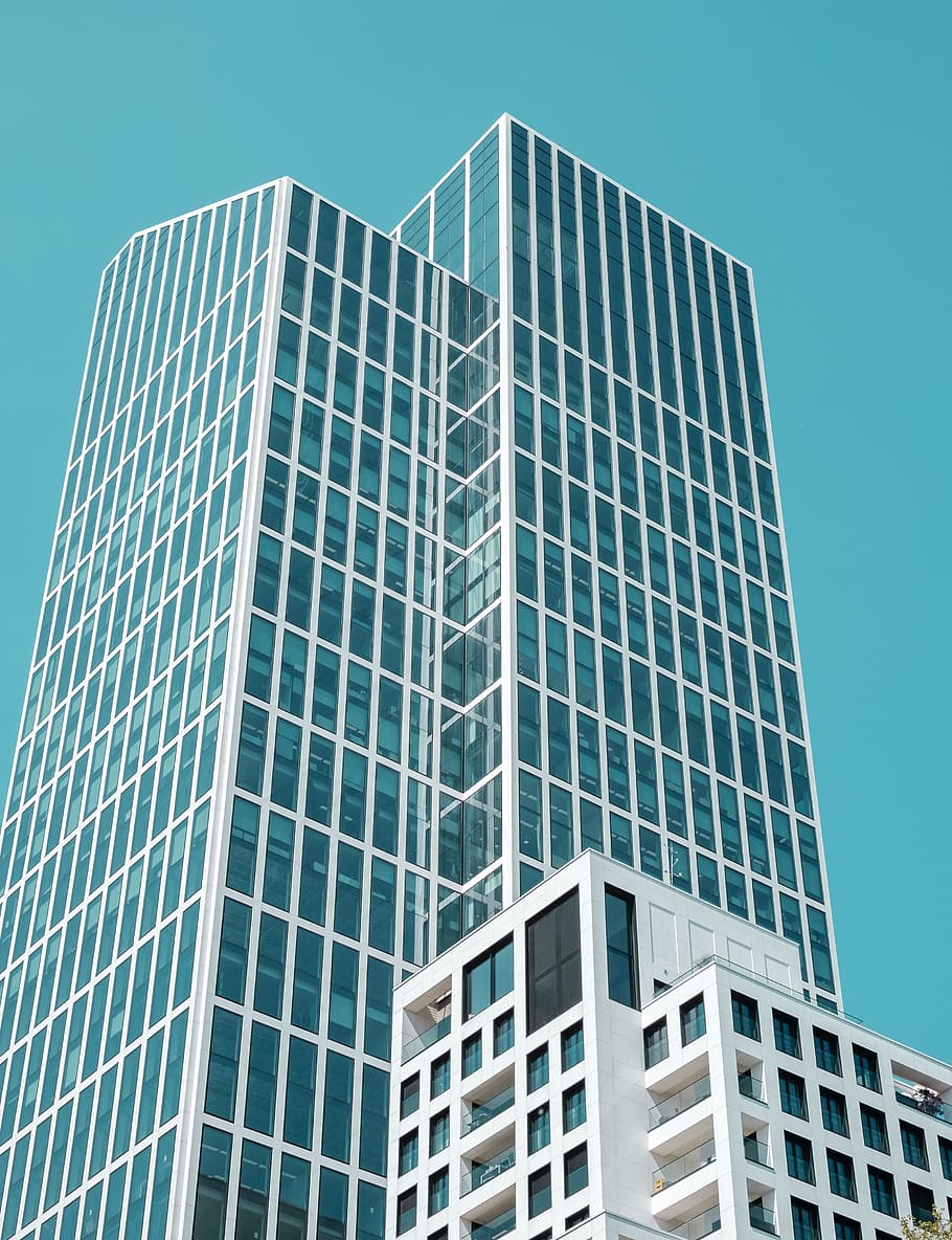 low angle photo of white building, white and teal tower building