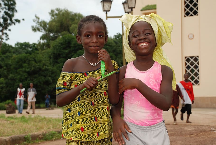 two girls smiling white standing near building, africa, people