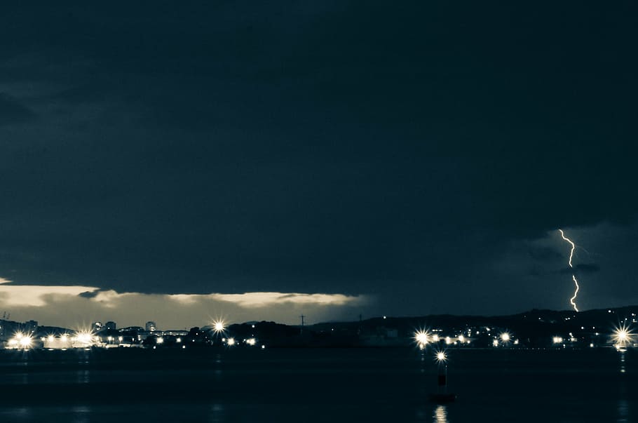 timelapse photography of city skyline during stormy weather HD wallpaper