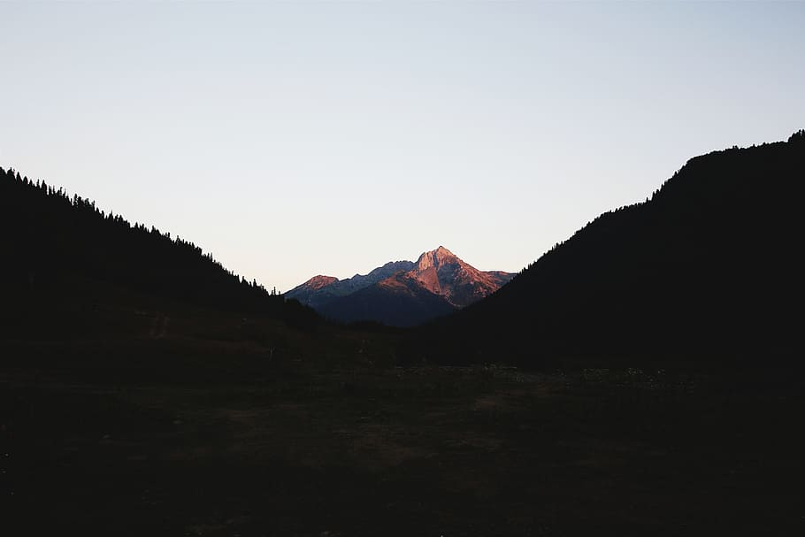 silhouette of valley and mountain, in distant photo of mountain peak HD wallpaper