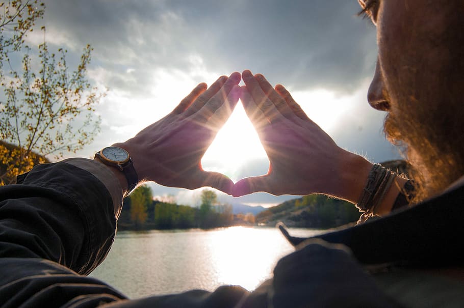 Sun shining through hands, man covering the sun using his hands HD wallpaper