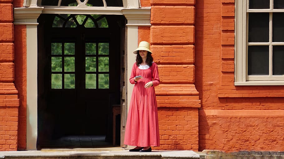 woman standing in front of the building near the door, dress