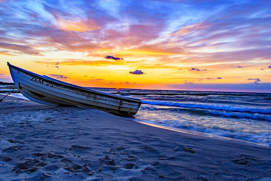 white and yellow boat dock on sand near wavy ocean under orange sky during golden hour HD wallpaper