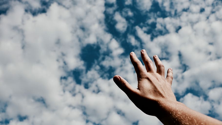 person hand reaching for the sky, person raising hand under clouds