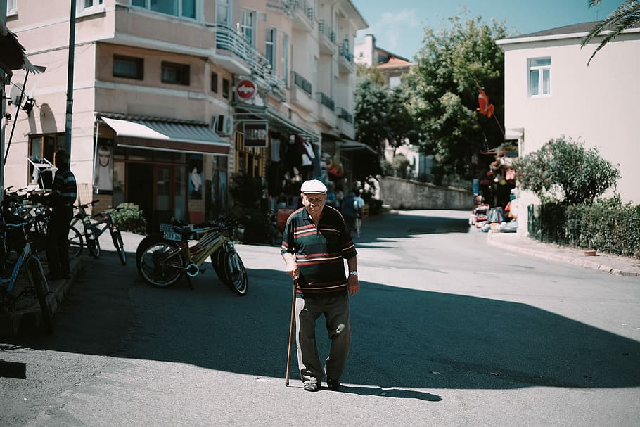 man walking while holding stick during daytime, photo of man standing on concrete road while using walking cane, HD wallpaper