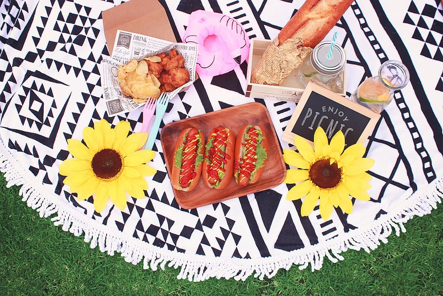 three hotdog sandwiches, chicken nuggets and chips, and baguette on picnic mat HD wallpaper