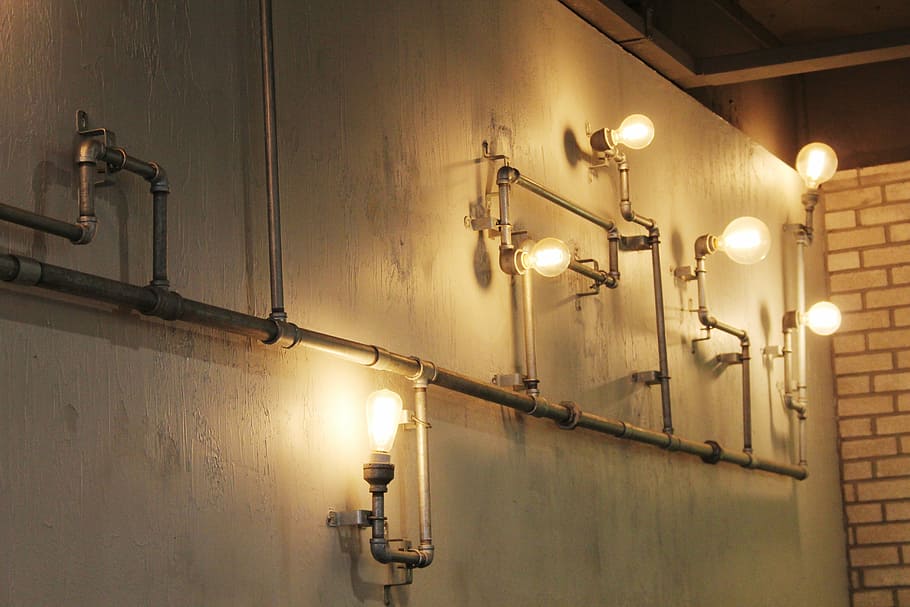 gray metal pipe-themed wall lamp inside room, cafe, light bulb