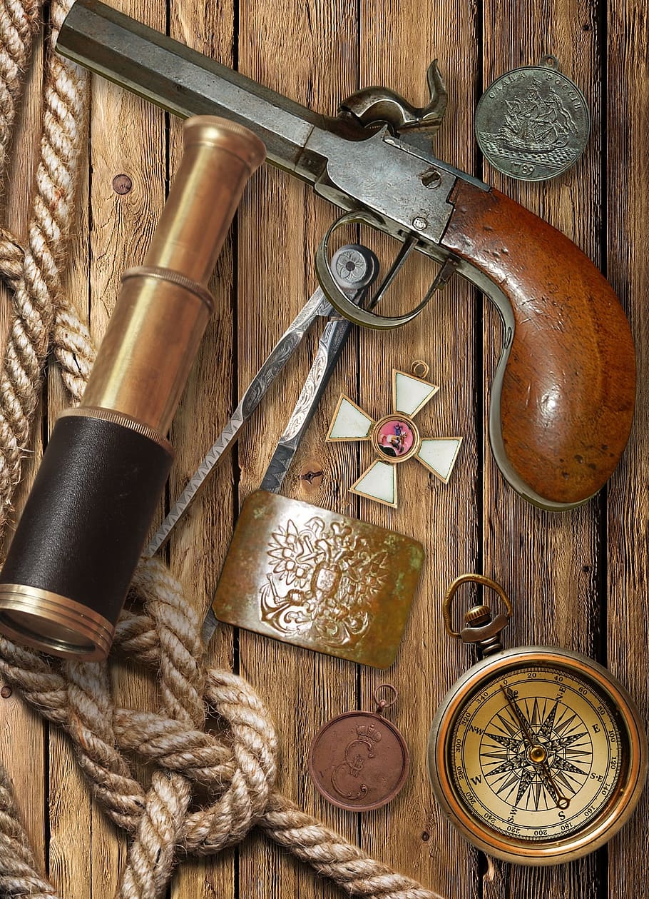vintage pistol and gold spyglass on table, flintlock pistol, compass