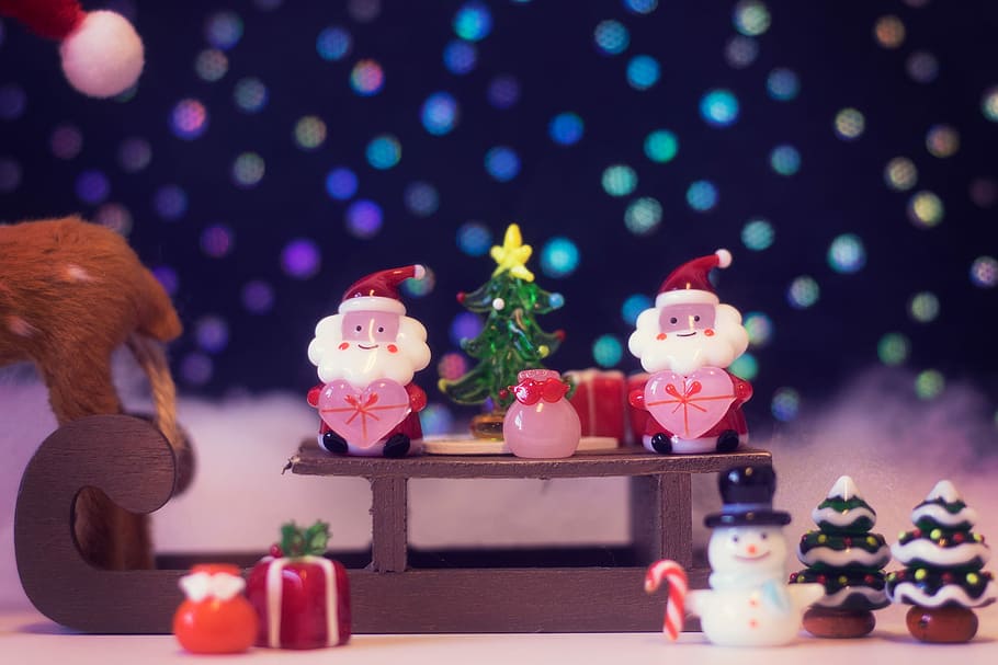 Shallow focus photography of two santas and snowman riding sled figures HD wallpaper