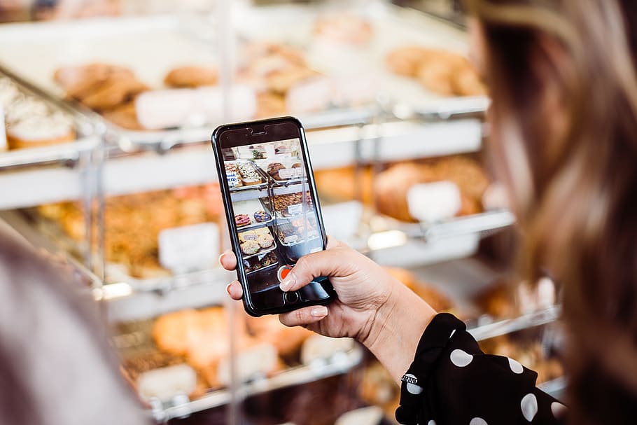 woman taking photo food display, woman holding iPhone 6 capturing bread HD wallpaper
