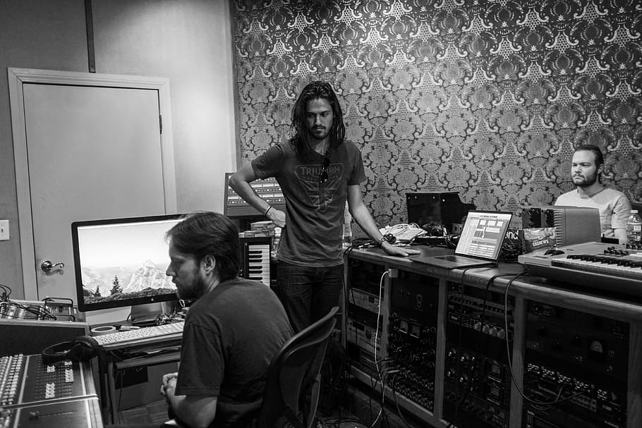 grayscale photograph of three men making music, man standing besides TV HD wallpaper