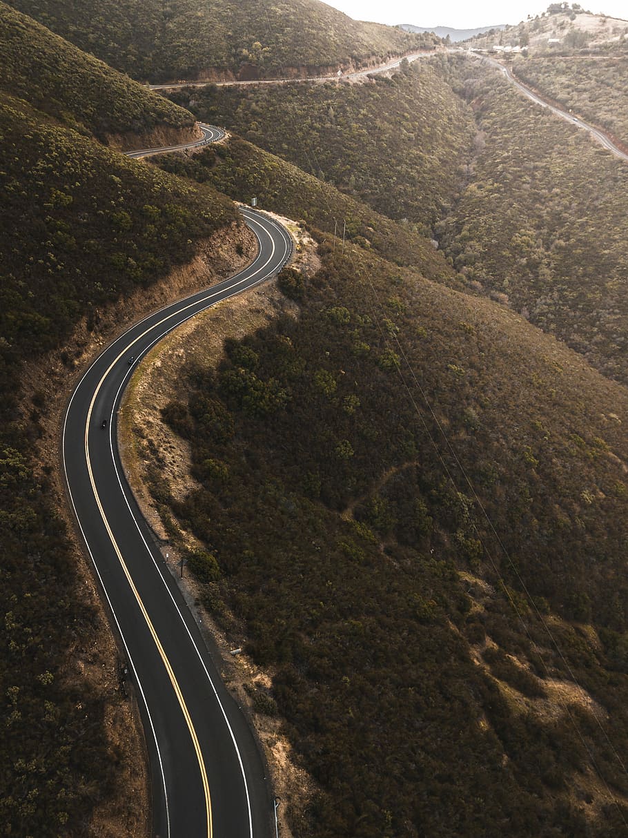 aerial photo of black concrete top road near green mountains, black asphalt road during daytime HD wallpaper