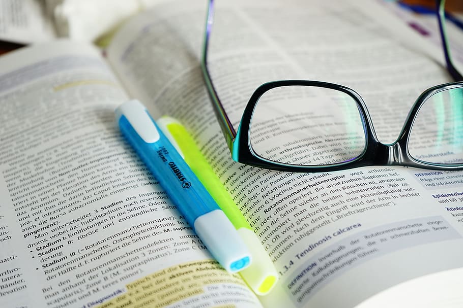 eyeglasses on book page, read, learn, text, highlighter, pen