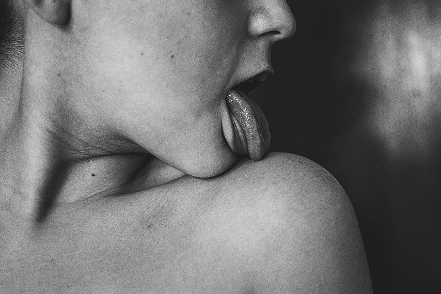 grayscale photo of woman licking her shoulder, grayscale photography of person licking his/her shoulder